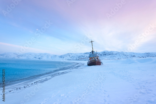 Beautiful seascape of Barents Sea with shipwreck of fishing boat on the shore in village Teriberka. Morning arctic winter landscape in Murmansk region of Russia