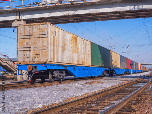 Long freight train of Idler flatcars loaded with intermodal 40-fts containers on the marshalling yard of Trans-Siberian Railway.
