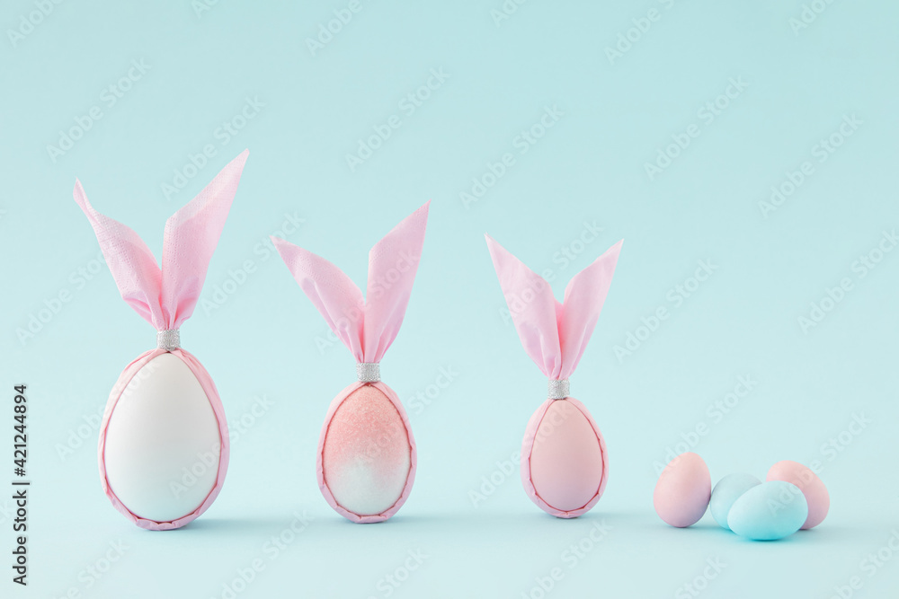 Easter pink and white eggs shaped as a bunny against pastel blue color. Creative minimal composition. Easter pink and white eggs shaped as a bunny against pastel blue color. Creative minimal composition.