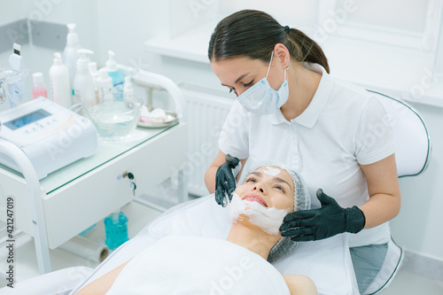 Mirthful lady enjoying skin therapy in modern clinic