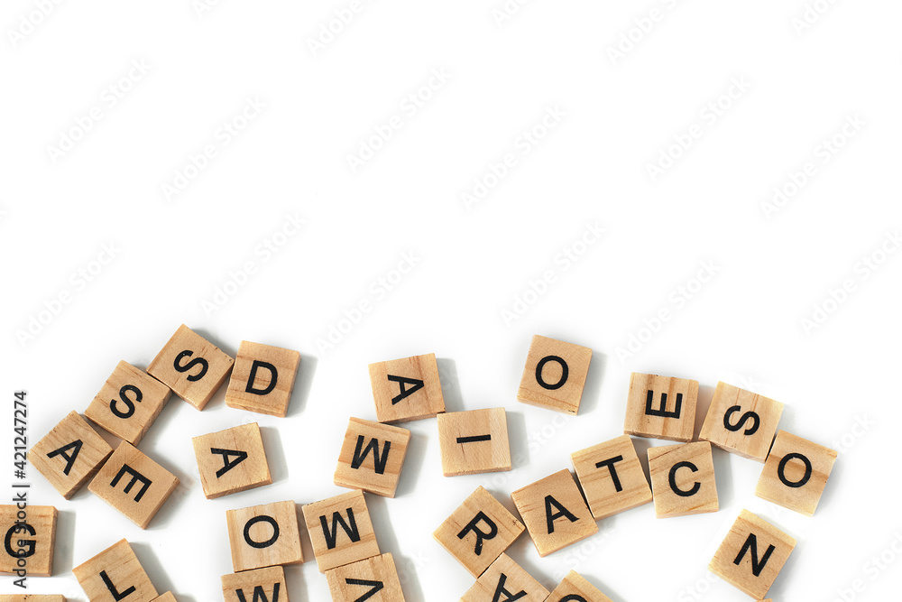 Top view of square wooden tiles with the English alphabet scattered on a white background with space for text. The concept of thinking development, grammar.