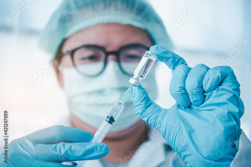 Doctor with syringe ready for injection of vaccine to patient. Vaccination concept..