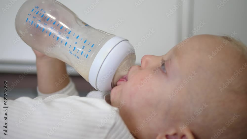 Caucasian baby drinking formula milk from a bottle Caucasian baby drinking formula milk from a bottle