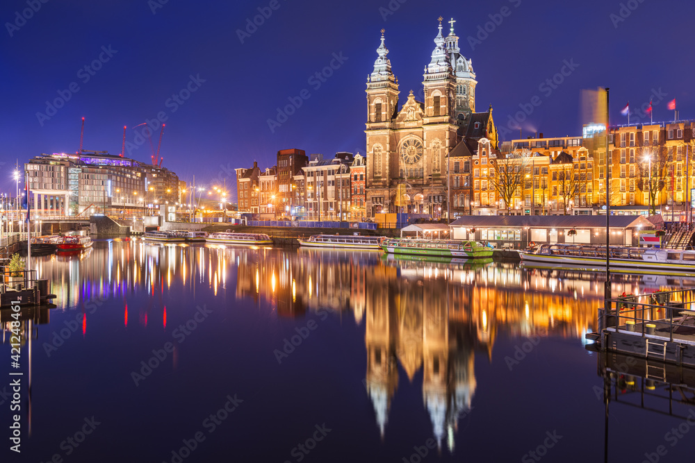 Amsterdam, Netherlands city center view with riverboats and the  Basilica of Saint Nicholas