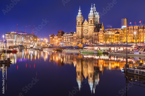 Amsterdam, Netherlands city center view with riverboats and the Basilica of Saint Nicholas