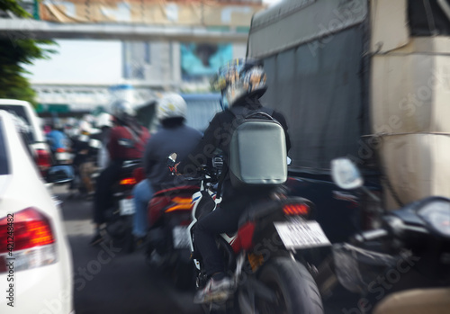 Rider on motorcycle on traffic with backpack