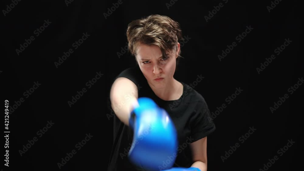 Young furious Caucasian woman boxing shadow looking at camera. Portrait of angry oppressed brunette lady fighting for freedom at black background. Strength and discrimination concept. Young furious Caucasian woman boxing shadow looking at camera. Portrait of angry oppressed brunette lady fighting for freedom at black background. Strength and discrimination concept.