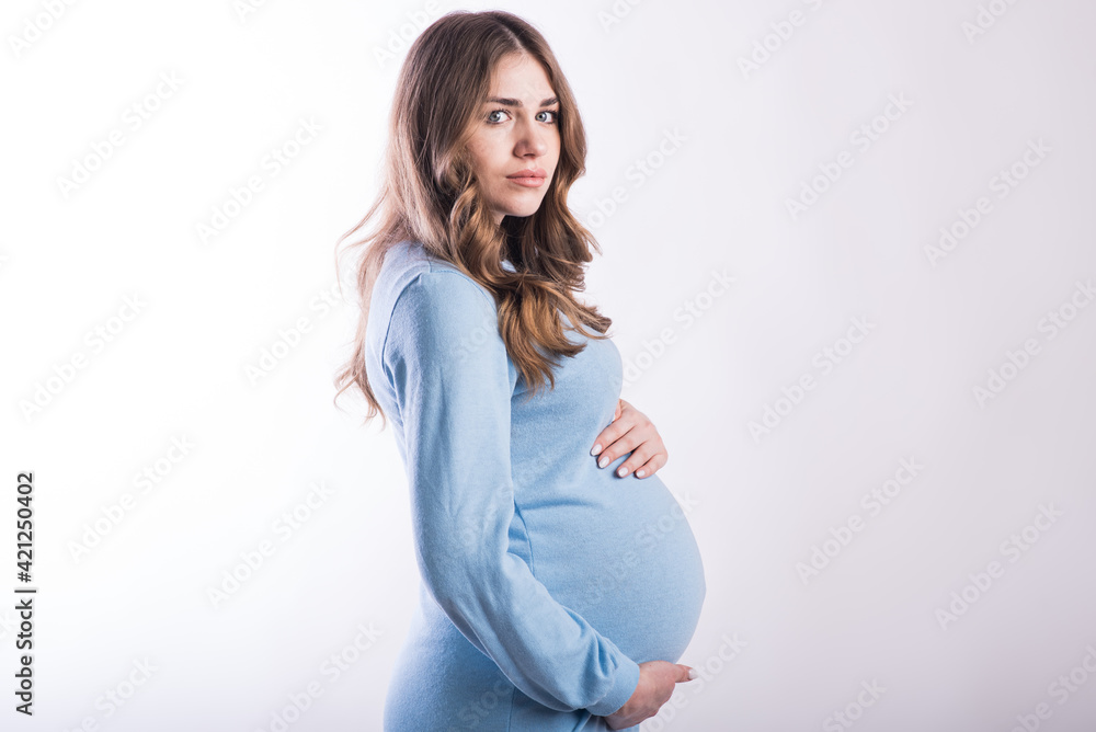 Portrait of a pregnant girl in the studio on a white background