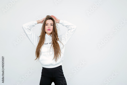 Beautiful young woman standing over white wall © Gbor
