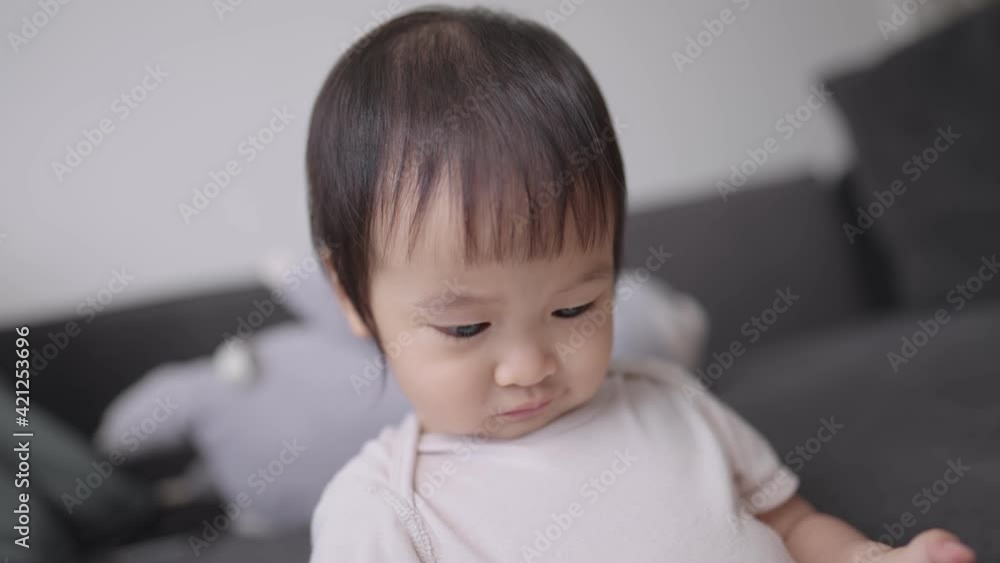 Asian female toddler looking at camera's screen, slow-motion cute adorable preschooler stares intently at joy stick she's holding, family activity indoor, family stay together, curiosity in kid Asian female toddler looking at camera's screen, slow-motion cute adorable preschooler stares intently at joy stick she's holding, family activity indoor, family stay together, curiosity in kid