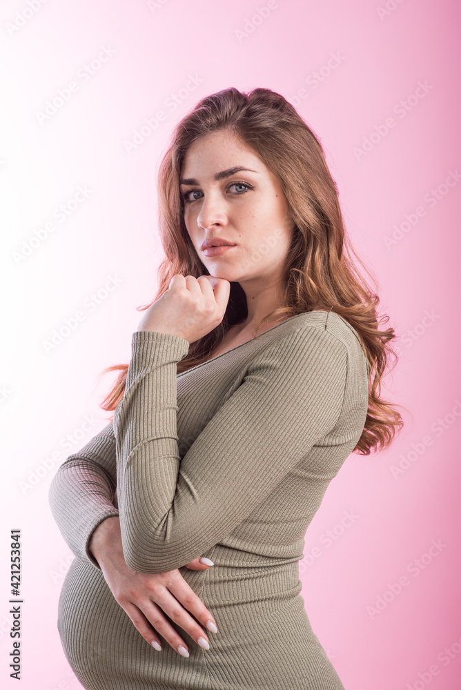 Portrait of a pregnant girl in the studio on a pink background Portrait of a pregnant girl in the studio on a pink background