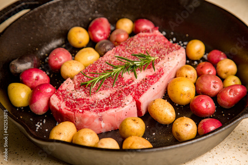 Red meat steak in a cast iron pan with potatoes