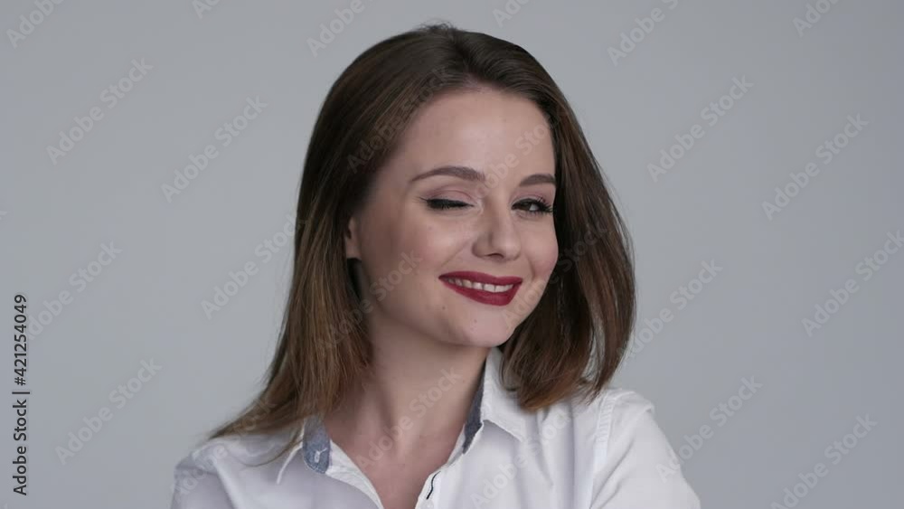 Young woman smiling and winking eyes. Close up of flirting girl face Young woman smiling and winking eyes. Close up of flirting girl face