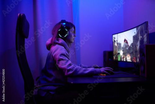 Young gamer girl sitting at pc