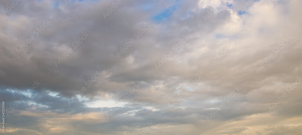 dramatic dark sky with rays and white clouds at sunset