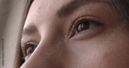 Beautiful brown woman eyes with thin lashes and perfectly formed eyebrows. Close up of female face. Details of natural beauty. 