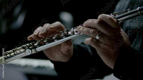 Close up footage of a person playing on his flute...