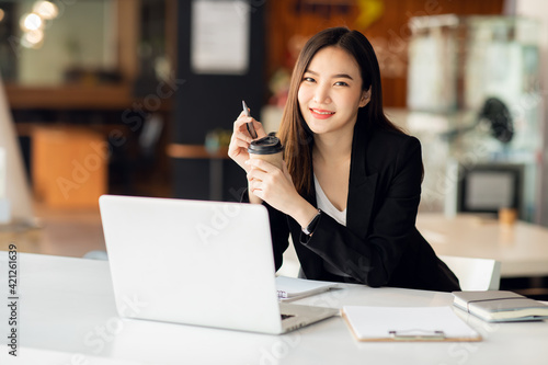 Portrait of Asian young female working on laptop 