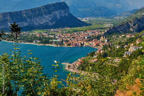 Panoramic view on Lake Garda from the Busatte-Tempesta trail near Nago-Torbole with the iron staircase, Torbole town surrounded by mountains in the summer time,Italy