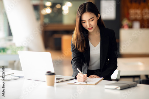 Portrait of Asian young female working on laptop 