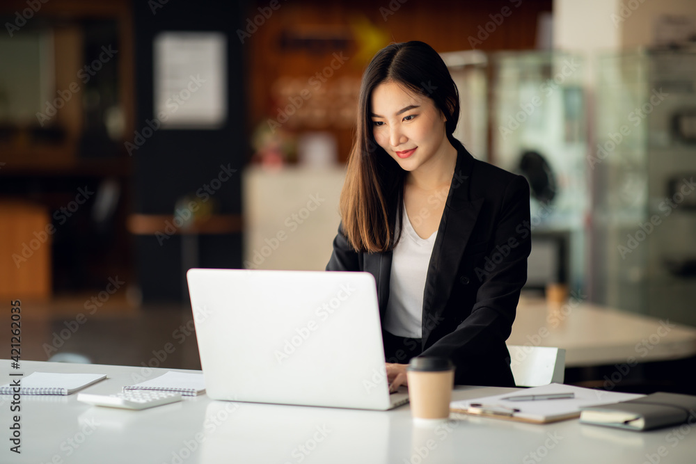 Portrait of Asian young female working on laptop at office Portrait of Asian young female working on laptop at office
