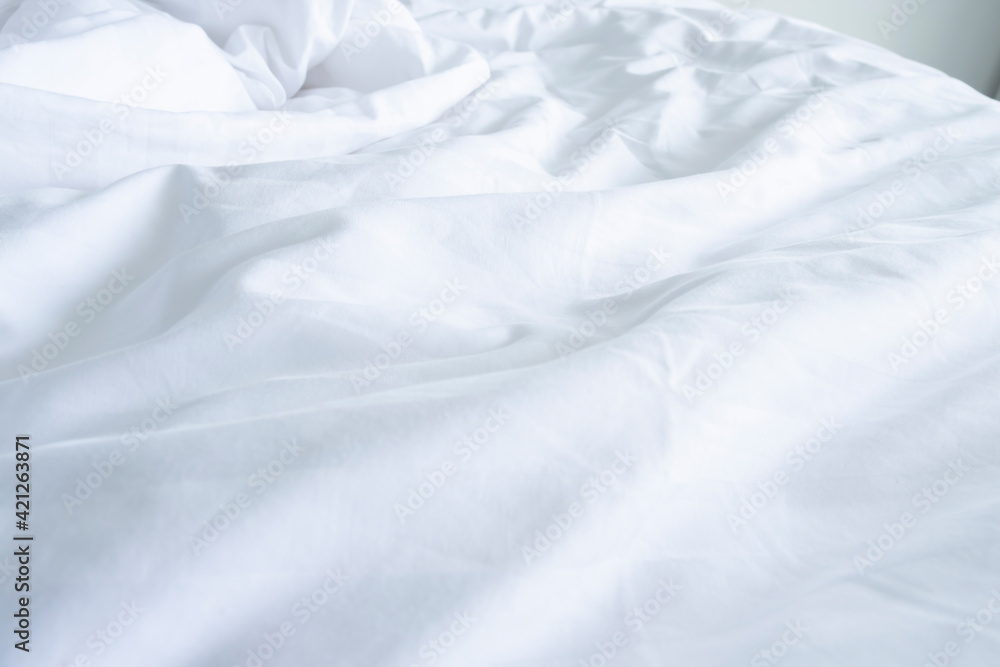 Close up messy Soft pillows on comfortable crumpled linen bed sheet in the hotel. Concept bed after sex night of new married couple or long relaxing weekend.