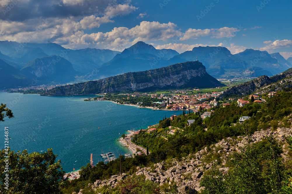 Panoramic view on Lake Garda from the Busatte-Tempesta trail near Nago-Torbole with the iron staircase,  Torbole  town surrounded by mountains in the summer time,Italy