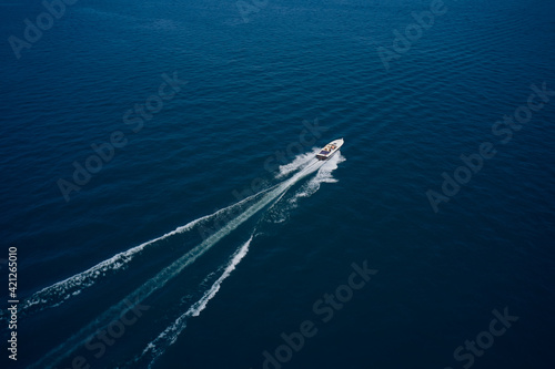 Top view of a white boat sailing to the blue sea. Large speed boat moving at high speed side view © Berg