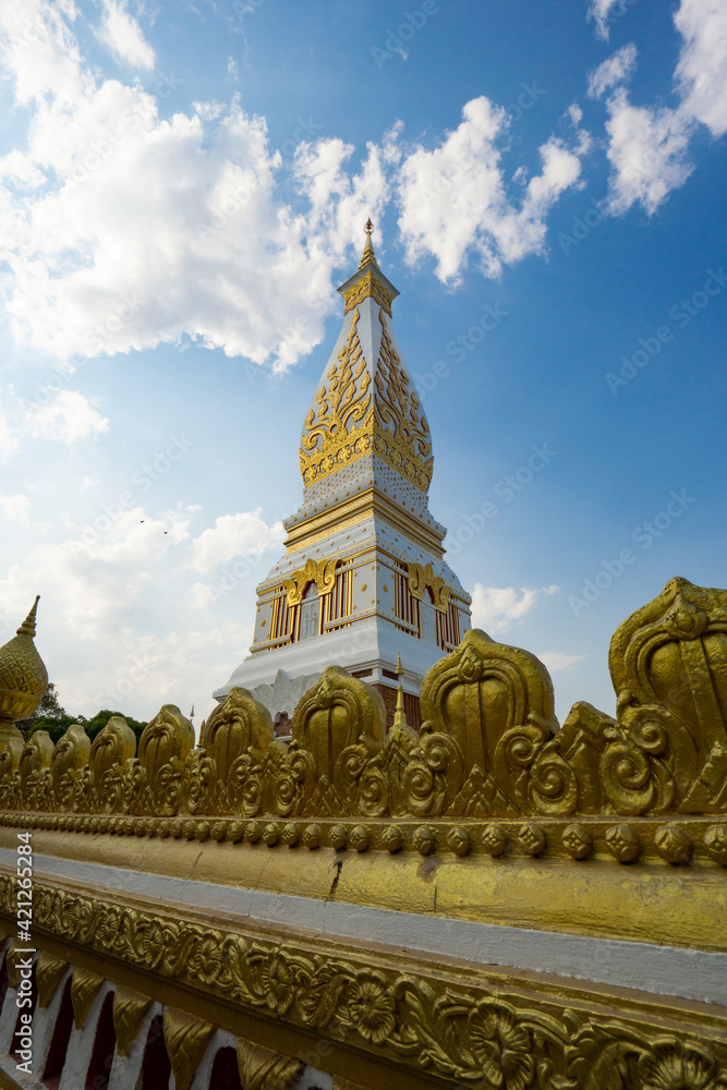 Naklejka premium The Pagoda of Wat Phra That Panom temple in Nakhon Phanom, Thailand in cloudy blue sky day with sunlight