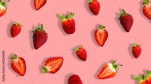 Different ripe strawberries and strawberry slices isolated on pink background. Banner.