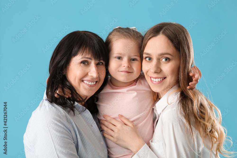 Young woman, her little daughter and mother on color background Young woman, her little daughter and mother on color background