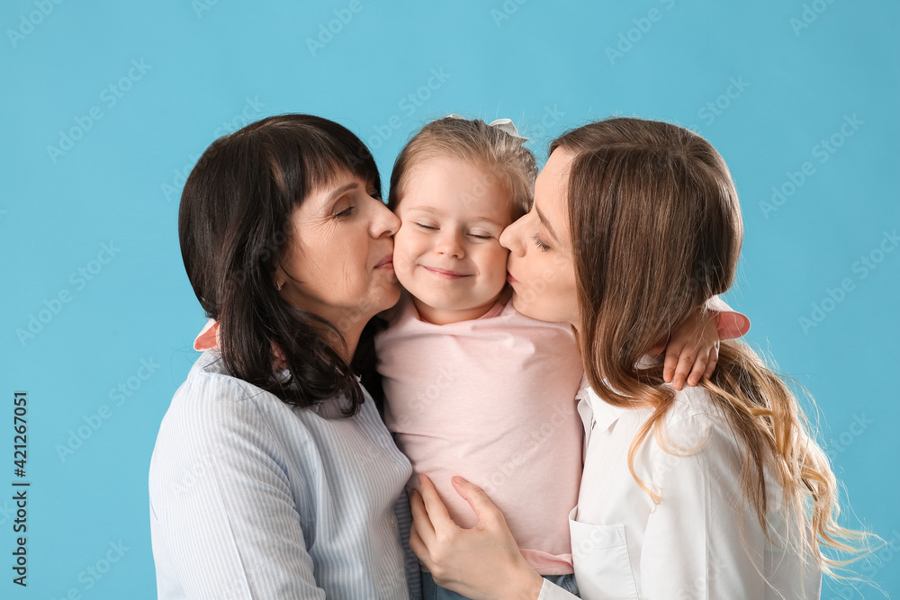 Young woman, her little daughter and mother on color background Young woman, her little daughter and mother on color background
