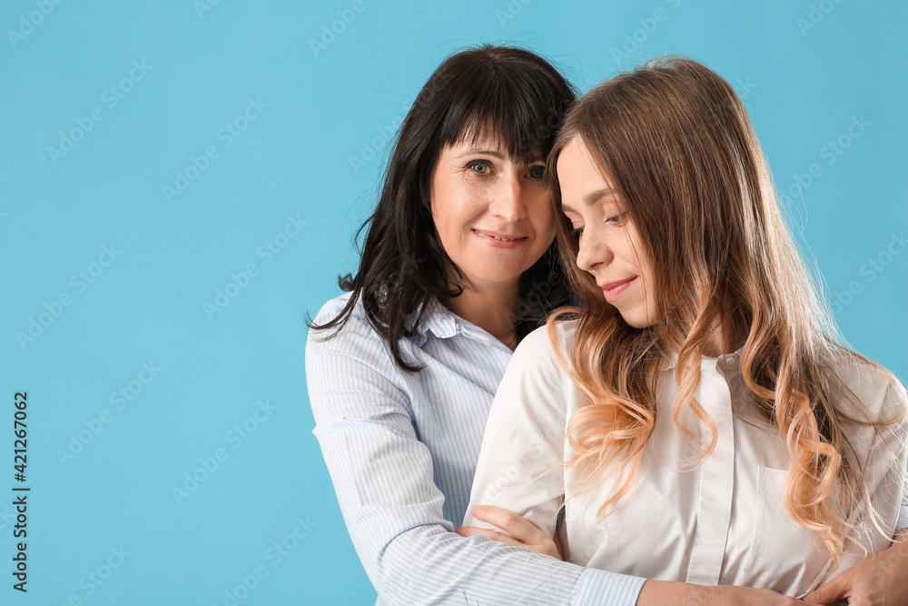 Young woman and her mother on color background Young woman and her mother on color background