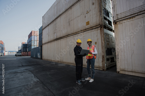 working engineer in the construction container yard.  worker and supervisor checking containers data. Container Shipping Logistics Engineering concept © nikomsolftwaer