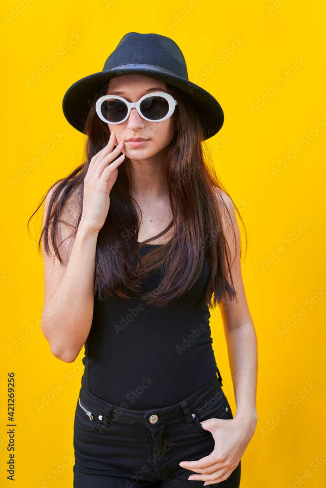 American flat vertical photo of a young caucasian woman on yellow background, hand over face American flat vertical photo of a young caucasian woman on yellow background, hand over face