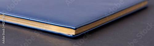 blue diary on a black background. Planning. Business concept