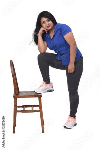 woman playing with a chair in white background,with your foot on the chair