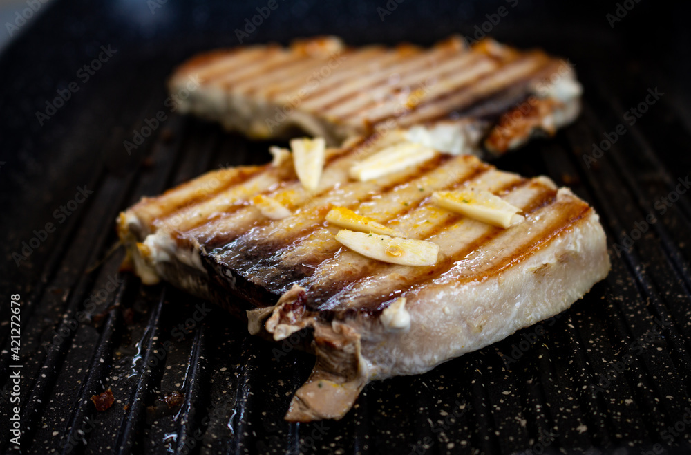 Pork steaks cooking on the grill. Selective focus. Pork animal in steak seasoned with garlic.