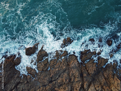 Fotografía vista aérea de las olas rompiendo contra las rocas