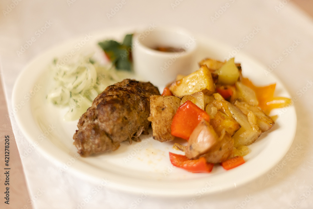 Lula Kebab with potatoes in a round white plate Lula Kebab with potatoes in a round white plate