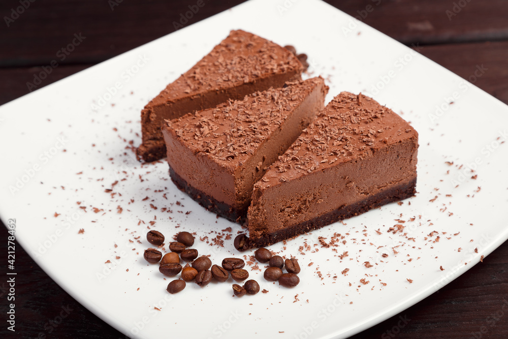 A piece of chocolate cake on a white plate on a wooden background A piece of chocolate cake on a white plate on a wooden background