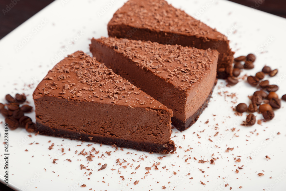 A piece of chocolate cake on a white plate on a wooden background A piece of chocolate cake on a white plate on a wooden background