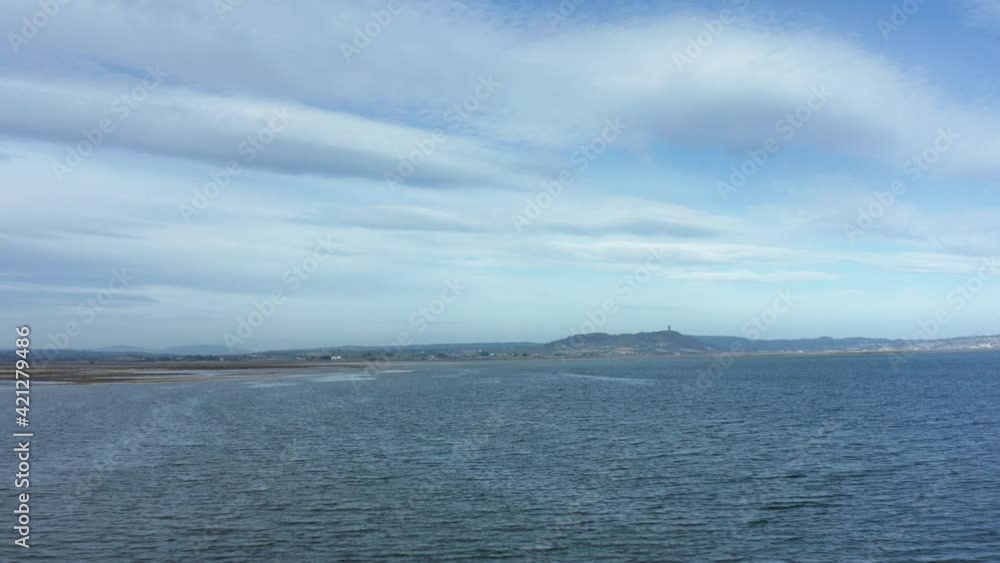 Scrabo tower drone flight over water on bright blue sunny day Scrabo tower drone flight over water on bright blue sunny day