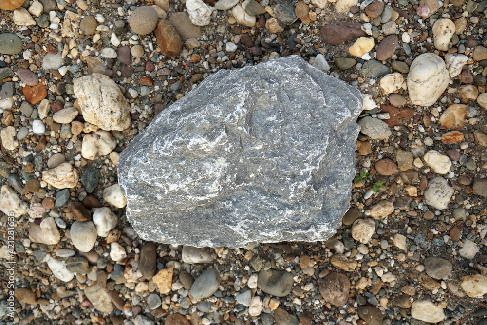gray limestone carbonate sedimentary rock on gravel background. Used in the industry, making roads, railways, making lime, burning, cement. gray limestone carbonate sedimentary rock on gravel background. Used in the industry, making roads, railways, making lime, burning, cement.