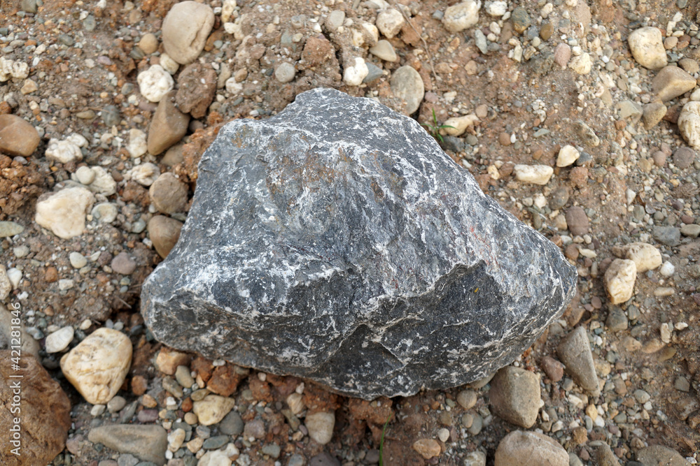 gray limestone carbonate sedimentary rock on gravel background. Used in the industry, making roads, railways, making lime, burning, cement. gray limestone carbonate sedimentary rock on gravel background. Used in the industry, making roads, railways, making lime, burning, cement.
