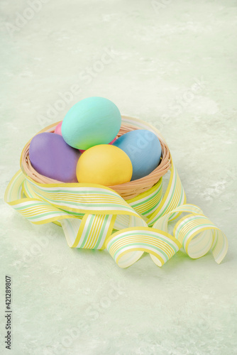 colorful easter eggs on green background decorated with ribbon