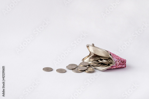 open wallet with scattered coins on a white background