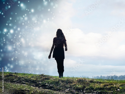 Junge Frau mit langen Haaren im Wetterwechsel von Schneeschauer zu Sonnenschein
