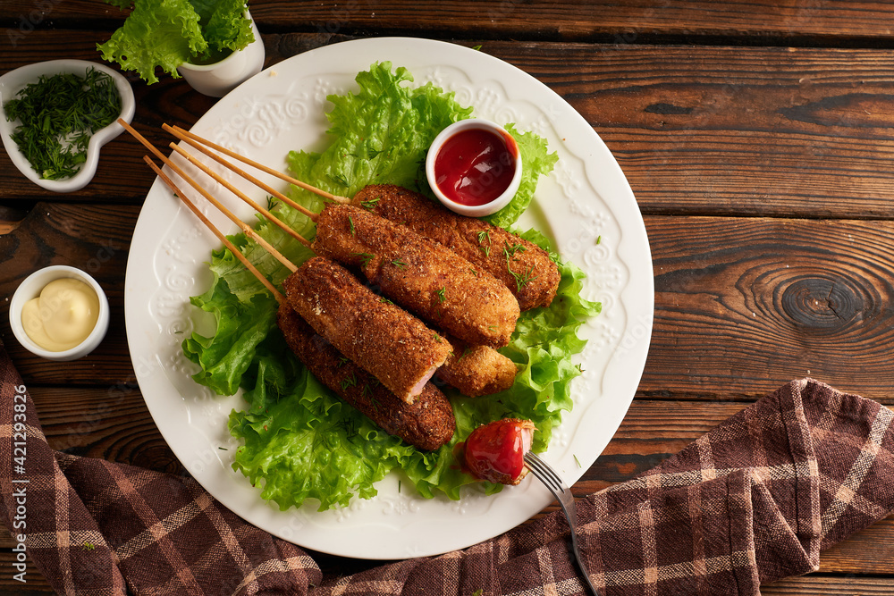 Tasty corn dog with sauce and salad served on white plate Tasty corn dog with sauce and salad served on white plate