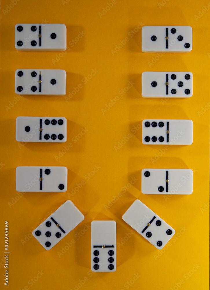 composition of dominoes lies on a yellow background. composition of dominoes lies on a yellow background.